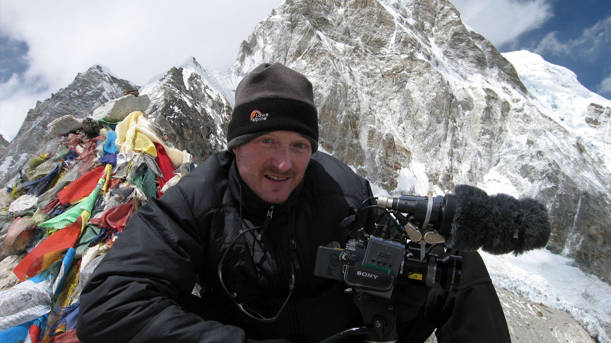 Army on Everest, Everest West Ridge Expedition, cameraman and Sony camera, prayer flags in the background