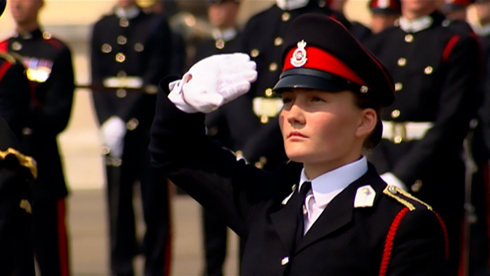 Army Officer Sandhurst, video garage image, young female army officer cadet salutes at the Sovereign’s passing out parade, in front of a group of army officer cadets in full military uniform at the Sandhurst Royal Military Academy