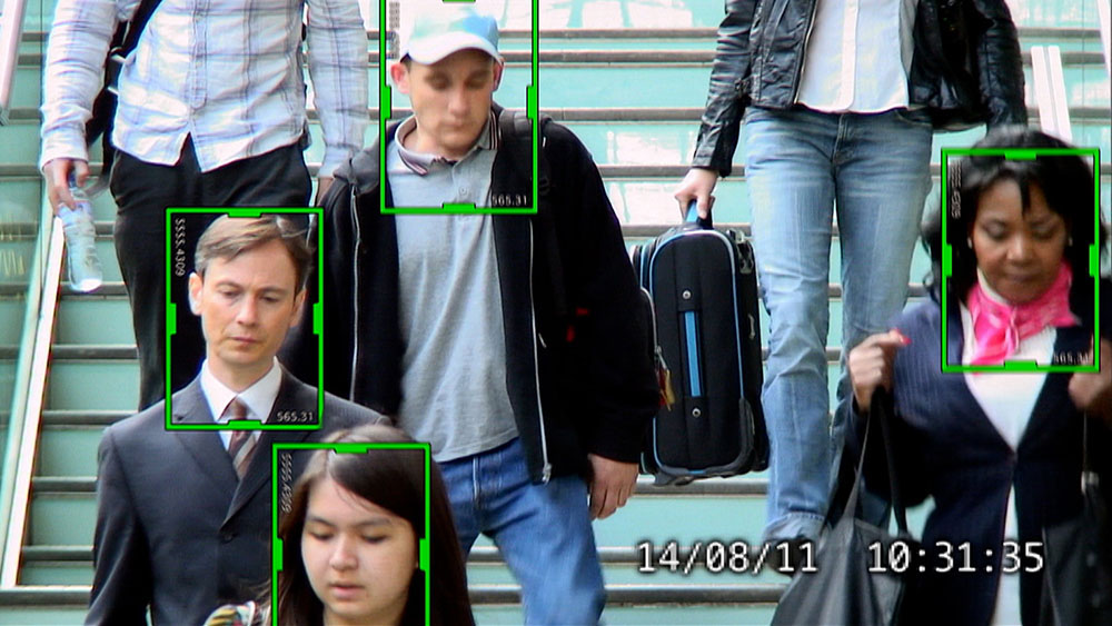 BAE Systems Intelligent Surveillance, video garage image, five actors playing members of the public descending a staircase at Kings Cross International train station, viewed from a surveillance camera, with green tracking image analysis security markers